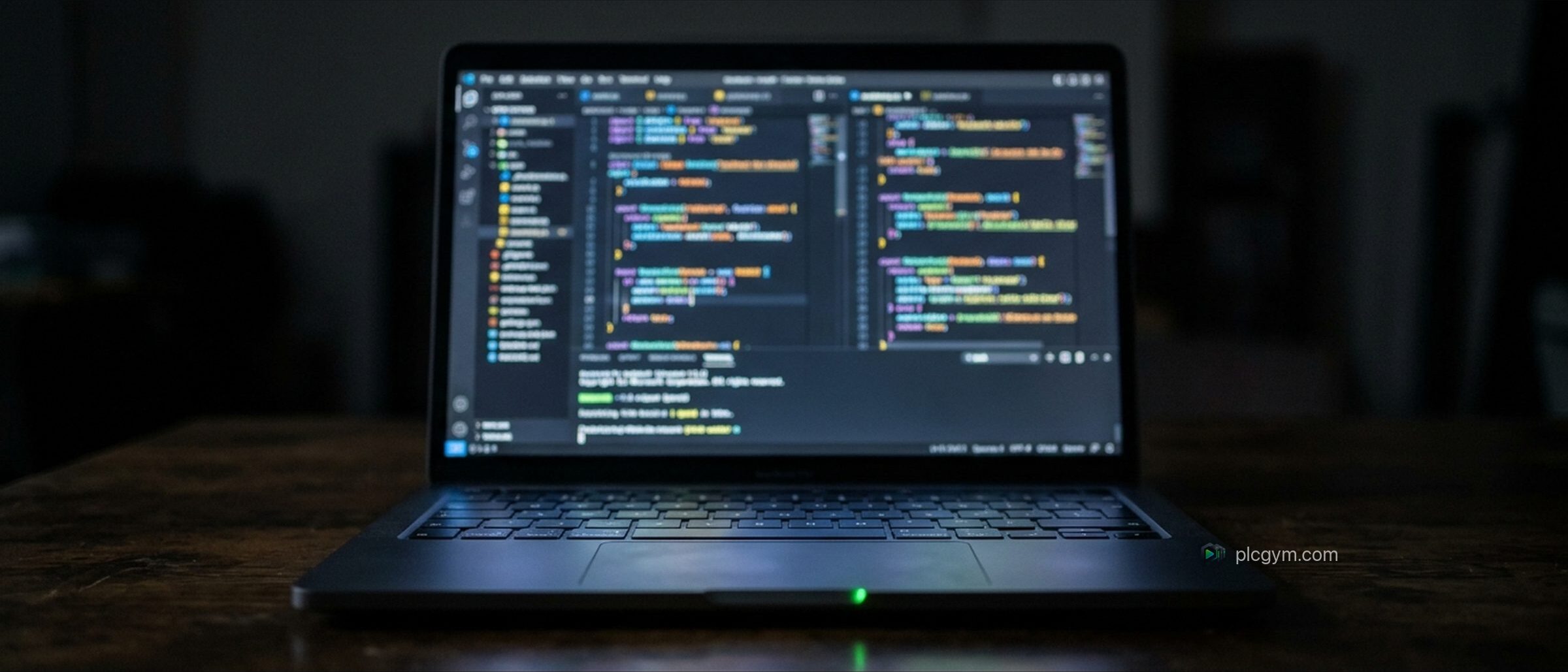 A laptop in a dark room showing a code editor full of colourful highlighted code.